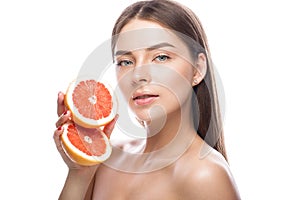 Beautiful young girl with a light natural make-up and perfect skin with Grapefruit in her hand . Beauty face.