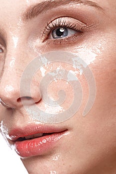 Beautiful young girl with a light natural make-up and perfect wet skin. Beauty face.