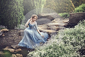 A beautiful young girl like Cinderella is walking in the garden.