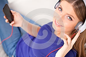 Beautiful young girl listens to music on headphones