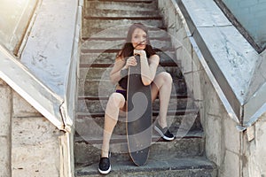 Beautiful young girl with a long board in the city. The concept of modern youth. Active fun holiday.