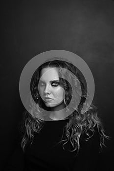 Beautiful young girl with long curly hair and smoky eye makeup