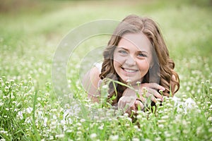 Beautiful young girl lying on the grass