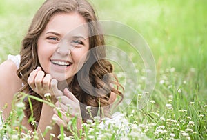 Beautiful young girl lying on the grass