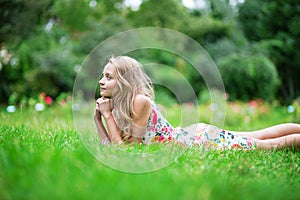 Beautiful young girl lying on the grass