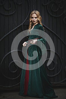 Beautiful young girl in the medieval dress holds a key