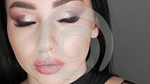 Beautiful young girl model posing in the studio with evening stylish smoky eyes make-up. Long black hair and brown eyes