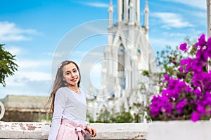 Beautiful young girl on the Ortiz Bridge with the famous gothic church of La Ermita in the city of Cali in Colombia photo