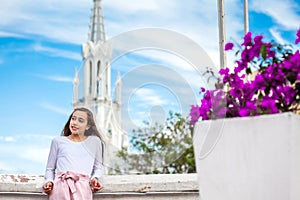 Beautiful young girl on the Ortiz Bridge with the famous gothic church of La Ermita in the city of Cali in Colombia photo