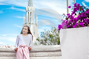 Beautiful young girl on the Ortiz Bridge with the famous gothic church of La Ermita in the city of Cali in Colombia photo