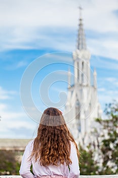 Beautiful young girl on the Ortiz Bridge looking at the famous gothic church of La Ermita built on 1602 in the city of Cali in Col photo