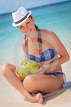 Beautiful young girl in paradise drinking coctail