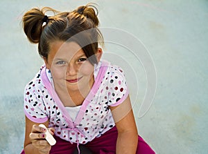 Beautiful young girl playing with sidewallk chalk.