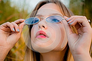 Beautiful young girl posing against high grass