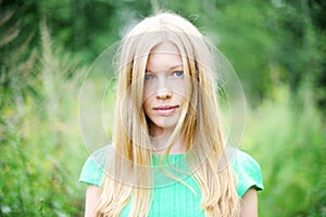 Beautiful young girl posing outdoors in a forest