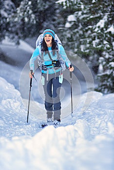 Beautiful young girl practicing ski touring in the woods