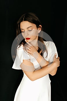 Beautiful young girl with red lipstick on her lips on a black background