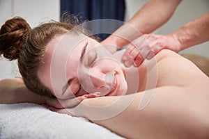 Beautiful young girl relaxing with hand massage at spa during a beauty treatment