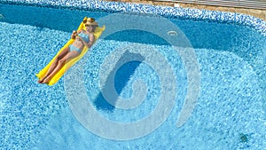 Beautiful young girl relaxing in swimming pool, woman swims on inflatable mattress and has fun in water on family vacation