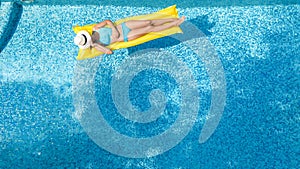 Beautiful young girl relaxing in swimming pool, woman swims on inflatable mattress and has fun in water on family vacation