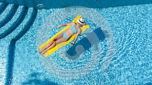 Beautiful young girl relaxing in swimming pool, woman swims on inflatable mattress and has fun in water on family vacation