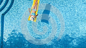 Beautiful young girl relaxing in swimming pool, woman swims on inflatable mattress and has fun in water on family vacation