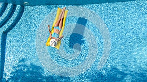 Beautiful young girl relaxing in swimming pool, woman swims on inflatable mattress and has fun in water on family vacation