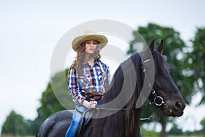 Beautiful young girl riding a horse in countryside