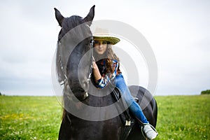 Beautiful young girl riding a horse in countryside