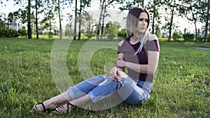 A beautiful young girl in ripped jeans and a blouse with bare shoulders