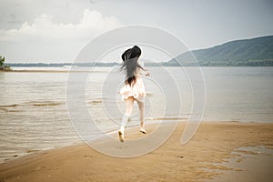 Beautiful young girl runs along the beach