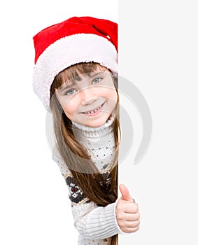 Beautiful young girl with santa hat standing behind white board. isolated on white background