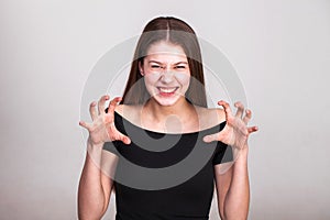 Beautiful young girl shouting and growling like an animal over white background