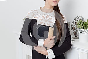 Beautiful young girl shows beznes woman advertises clothing catalog business style in bright light studio photo