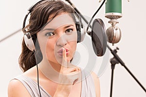 Beautiful young girl singing in music studio