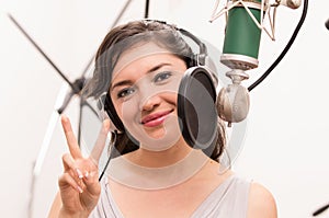 Beautiful young girl singing in music studio