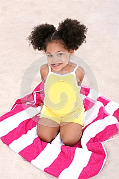 Beautiful Young Girl Sitting On Beach Towel In The Sand