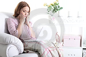 Beautiful young girl sitting in a chair with a laptop