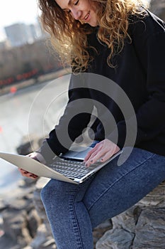 Beautiful young girl sitting with a laptop in the park. The possibilities are endless on the Internet