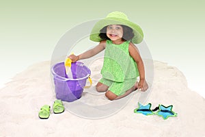 Beautiful Young Girl Sitting In the Sand Playing