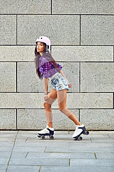 Beautiful young girl skating on roller skates