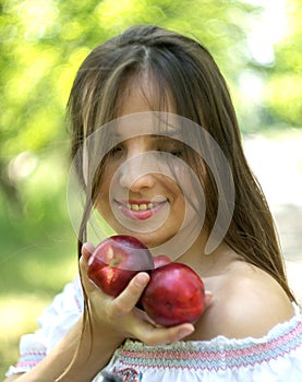 Beautiful young girl smelling a fresh fruit