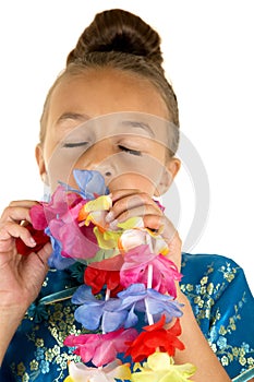 Beautiful young girl smelling a paper lei eyes closed