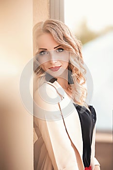 Beautiful young girl standing near the stone wall. Portrait pretty young fashion girl near a stone wall. Beautiful blonde woman