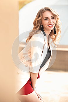 Beautiful young girl standing near the stone wall. Portrait pretty young fashion girl near a stone wall. Beautiful blonde woman