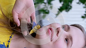 beautiful young girl straightens her blond hair yellow blouse with blue embroidery earrings bird feathers yellow and