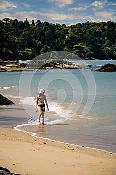 Beautiful young girl strolling on the beaches and lagoons of Khao Lak at sunset