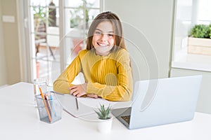 Beautiful young girl studying for school using computer laptop smiling looking side and staring away thinking