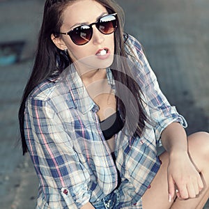 Beautiful young girl in sunglasses is going to swallow pills.