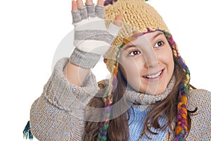 Beautiful young girl in warm winter clothes smiles and waving